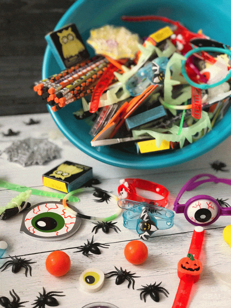 A teal bowl full of halloween themed non-food creative treats for an inclusive food allergy friendly Halloween