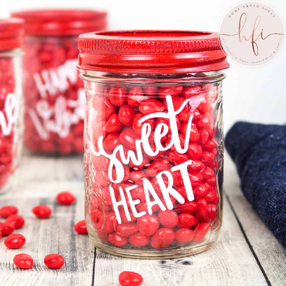 Jars filled with red cinnamon candies and red lids are decorated to say things like "sweetheart"