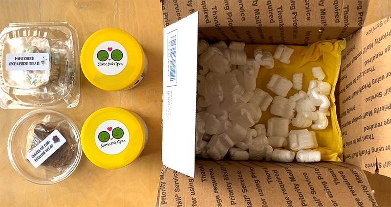 open box full of packing peanuts and slime sweetpea slime and extras sitting on the table