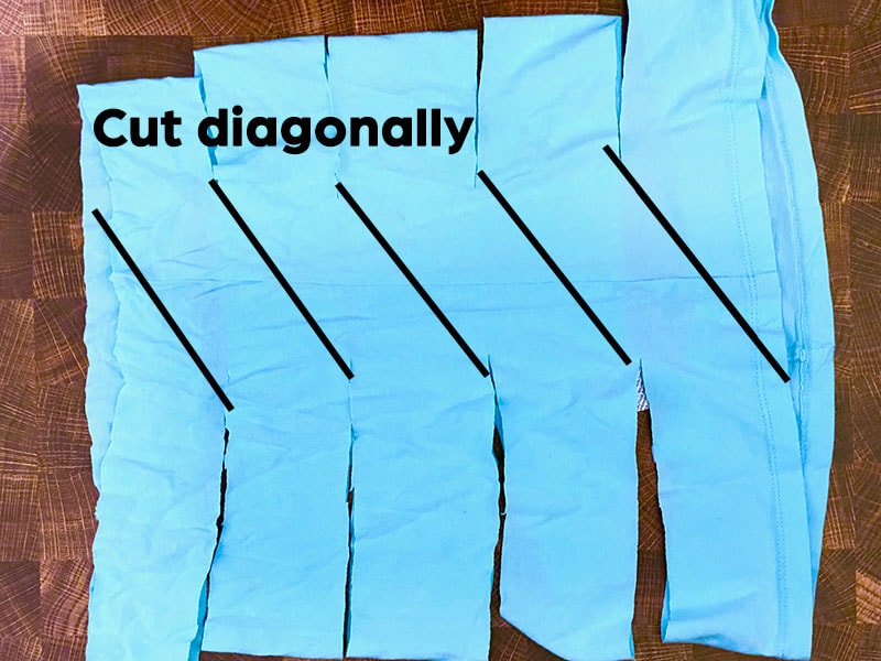 blue fabric is arranged where the top fabric loop is visible. Cut lines are labeled in black to show a diagonal cut.