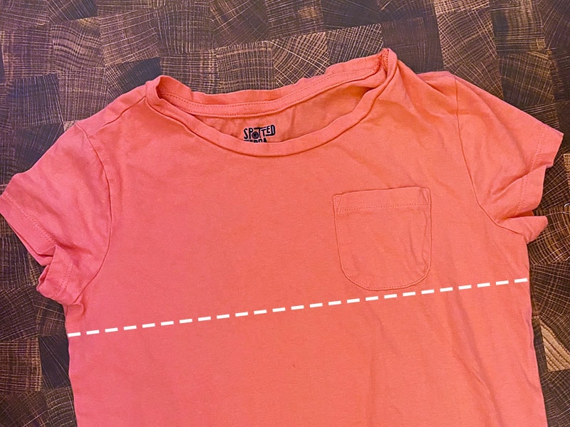 a coral shirt sits on a wood background
